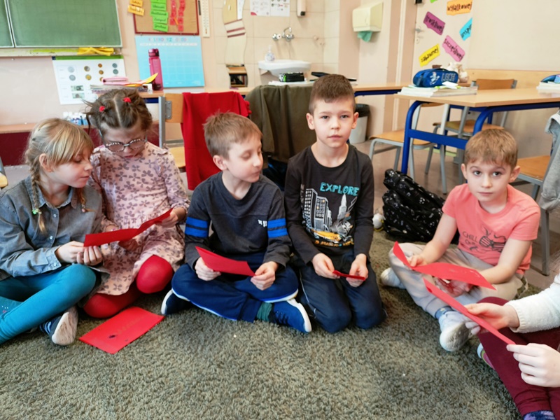 Dzieci czytają kartki walentynkowe.
