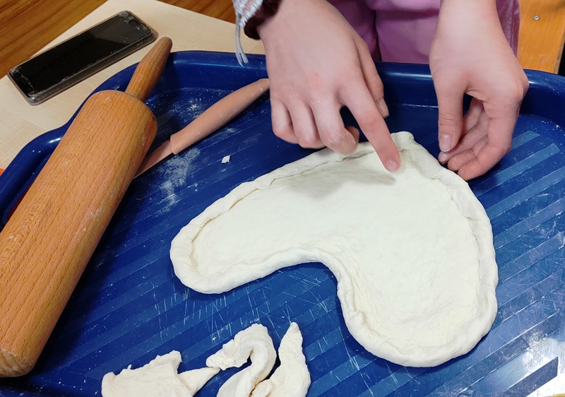 Uczennica formuje pizzę w kształcie serca