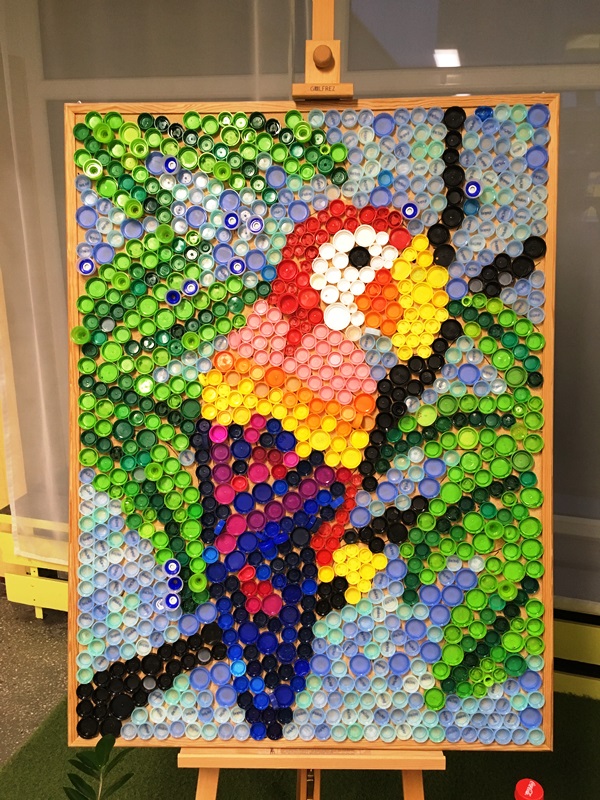 Mozaika z plastikowych nakrętek – kolorowa papuga.